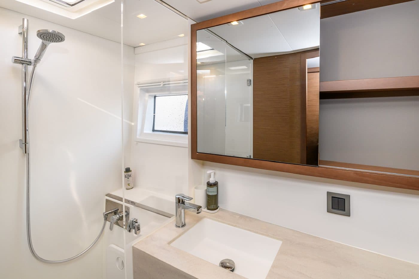 Ensuite bathroom with a stone vanity, framed mirror, and a walk-in shower